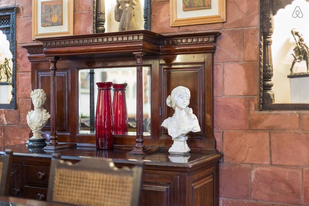 Antique cabinet with busts and red glass vases